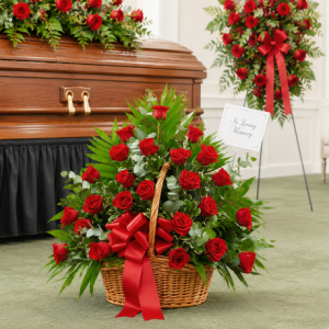 Elegant funeral roses arranged in a wicker basket displayed beside a casket at a memorial service.
