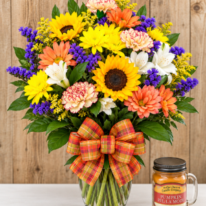 Fall floral arrangement with sunflowers, colorful seasonal flowers, plaid bow, and pumpkin candle at Wendy’s Flowers.