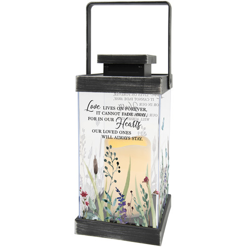 Elegant sympathy lantern surrounded by fresh seasonal flowers on a table, creating a comforting memorial tribute for funeral services, celebrations of life, or sending condolences to a loved one's home.