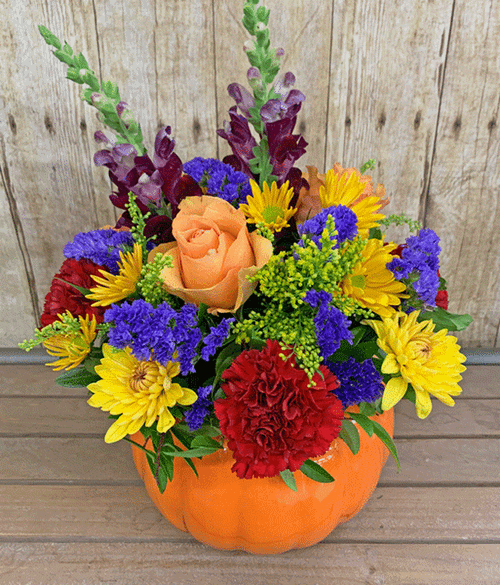 Fall flowers arranged in a ceramic pumpkin container